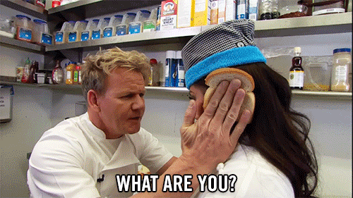 Gordon Ramsey holding two pieces of bread against a woman's head while making her say she is 'an idiot sandwich.'